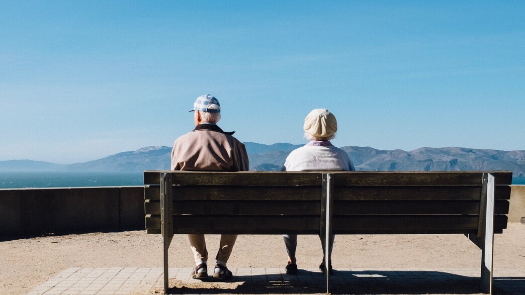 זוג מבוגר על ספסל בוהה אל האופק (צילום: Matthew Bennett, Unsplash)