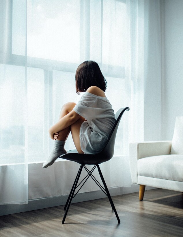 אישה יושבת על כיסא מול חלון (אילוסטרציה: Anthony Tran , unsplash)