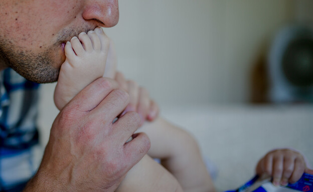 גבר מנשק תינוק (צילום: שיר תורם, פלאש 90)