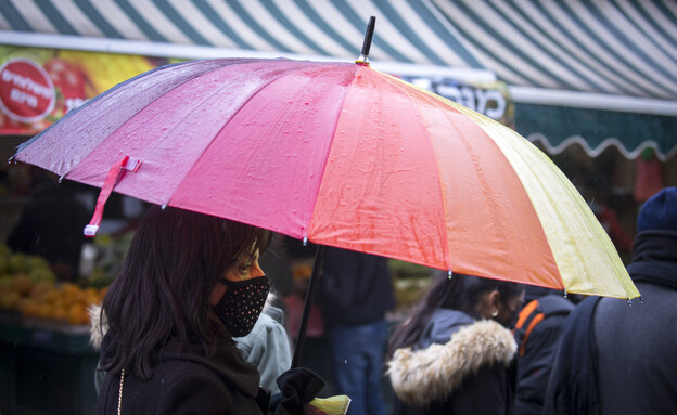 אנשים בגשם (צילום: אוליבייה פיטוסי, פלאש 90)
