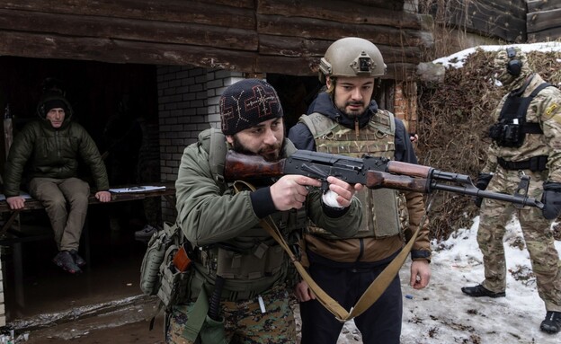 מתנדבים מדריכים אזרחים אוקראיניים כיצד להשתמש בנשק (צילום: Chris McGrath/Getty Images)