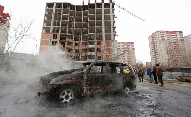 תושבי דונייצק באים לבחון את המכוניות שנפגעו בהפצצה (צילום: רויטרס)