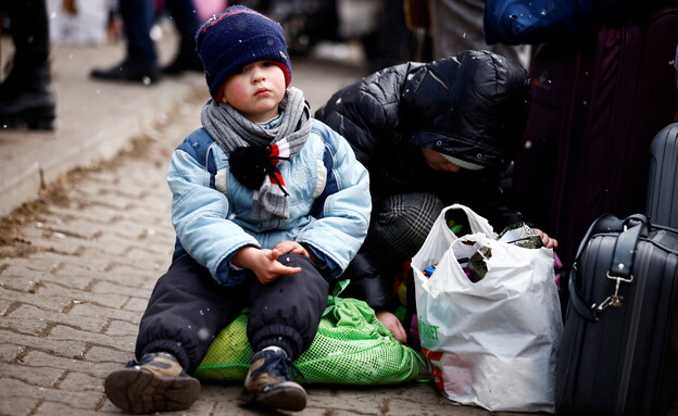 ילד יושב מחוץ למרכז אירוח זמני בפולין (צילום: reuters)