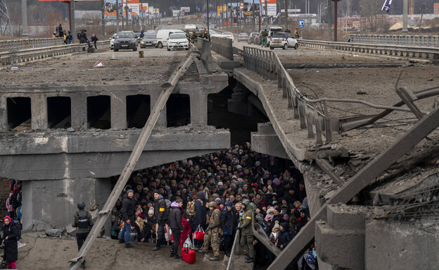 אוקראינים מצטופפים מתחת לגשר הרוס כשהם מנסים לברוח (צילום: ap)