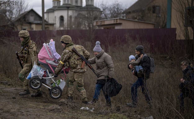 Ukrainian soldiers help a fleeing family cross a river (Photo: ap)