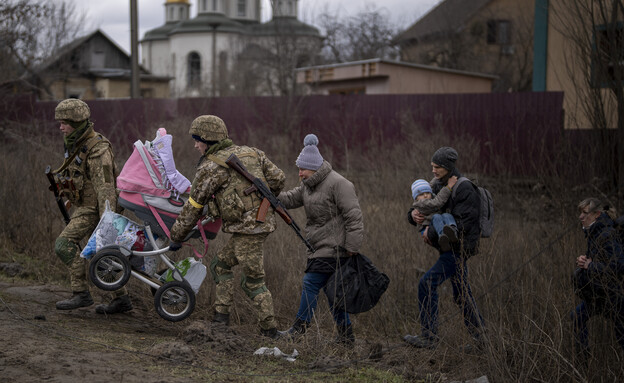 חיילים אוקראינים עוזרים למשפחה בורחת לחצות את נהר  (צילום: ap)