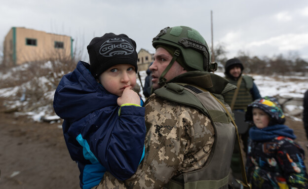 חייל אוקראיני מחזיק ילד בזמן פינוי האזרחים מהעיר אירפין שבאוקראינה (צילום: getty images)