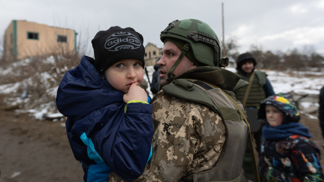 חייל אוקראיני מחזיק ילד בזמן פינוי האזרחים מהעיר אירפין שבאוקראינה