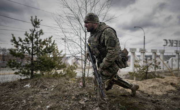 חייל אוקראיני באירפין שבפאתי קייב (צילום: AP)