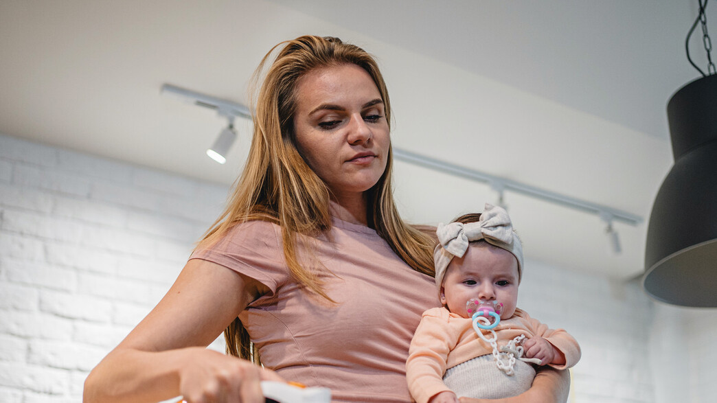 אמא עושה עבודות בית בזמן טיפול בתינוק