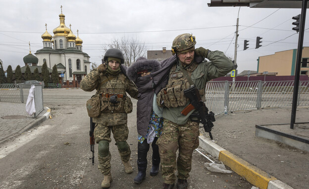 חייל אוקראיני מחזיק ילד בזמן פינוי האזרחים מהעיר אירפין שבאוקראינה (צילום: AP Photo/Andriy Dubchak, getty images)