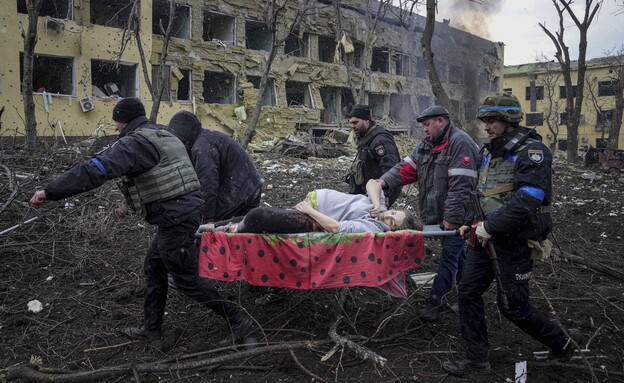 אוקראינה: כוחות הצלה מפנים יולדת מבית חולים שהופצץ (צילום: AP)