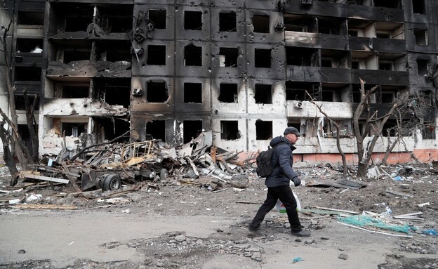 A man walks near a building destroyed in shelling in the city of Mariupol (Photo: News 12)
