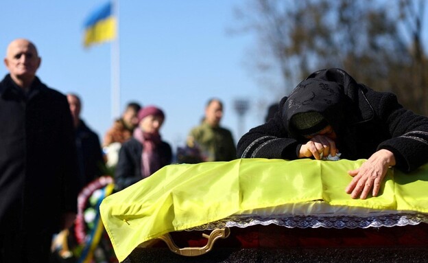 אדם מתאבל בהלווייתו של חייל אוקראיני (צילום: reuters)