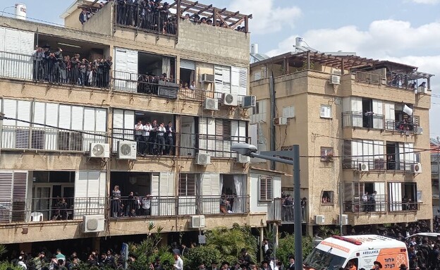 אנשים משקיפים במרפסות ליד בית הרב קניבסקי (צילום: N12)