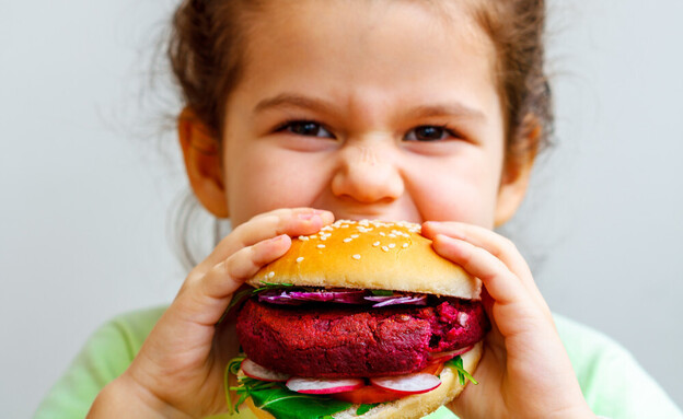 ילדה אוכלת המבורגר טבעוני (צילום: Nina Firsova, shutterstock)