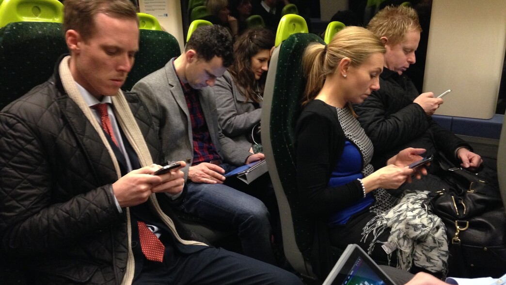 נוסעים ברכבת ללונדון מסתכלים על טלפוניים סלולריים ואייפד (צילום: John Keeble, Getty Images)