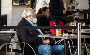 גבר מבוגר עם מסיכת פנים יושב בבית קפה (אילוסטרציה: shutterstock)