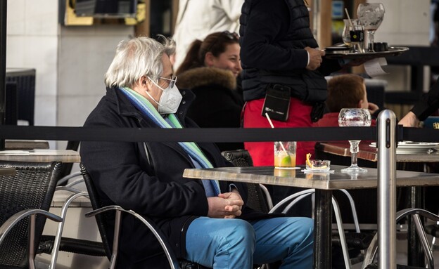 גבר מבוגר עם מסיכת פנים יושב בבית קפה (אילוסטרציה: shutterstock)