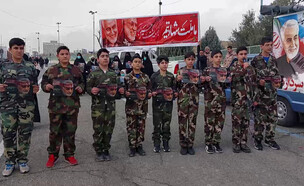 9 נערים מחזיקים בדיוקנו של סרדאר מול טקס הניצחון על מתנגדי המשטר (צילום: חדשות 12)