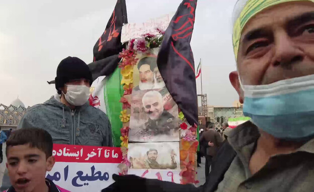 תושב טהראן עם מיצג הזיכרון להרוגי המשטר (צילום: חדשות 12)