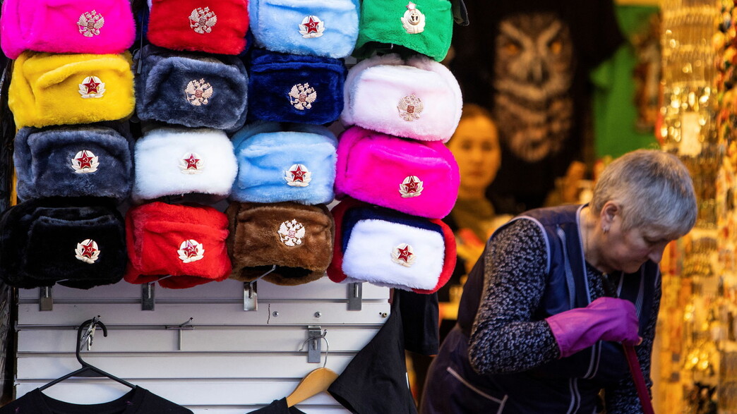 אישה מנקה ליד חנות כובעים לתיירים, מוסקווה רוסיה