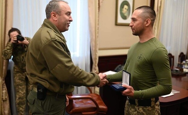 Ukrainian soldier May Snakes receives a certificate of appreciation after his release from Russian captivity