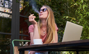 אישה מעשנת ועובדת על לפטופ (צילום: Aleksandra Belinskaya, shutterstock)