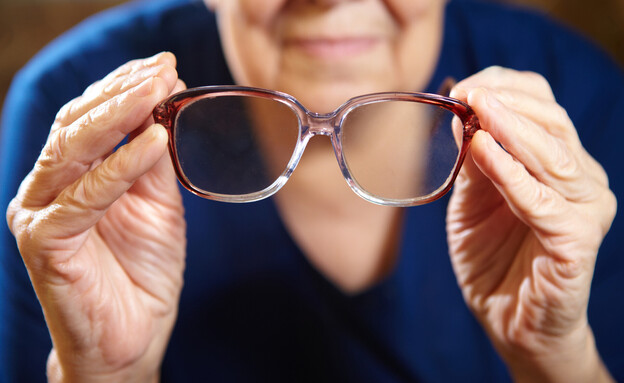 קשישה מחזיקה משקפיים (אילוסטרציה: docent, shutterstock)