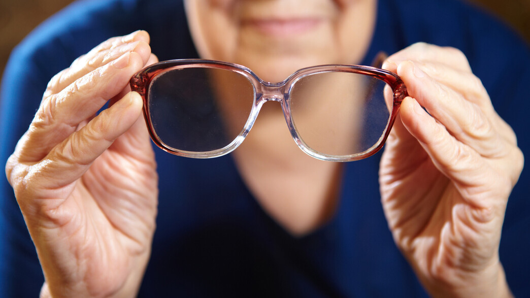 קשישה מחזיקה משקפיים קשישה מחזיקה משקפיים