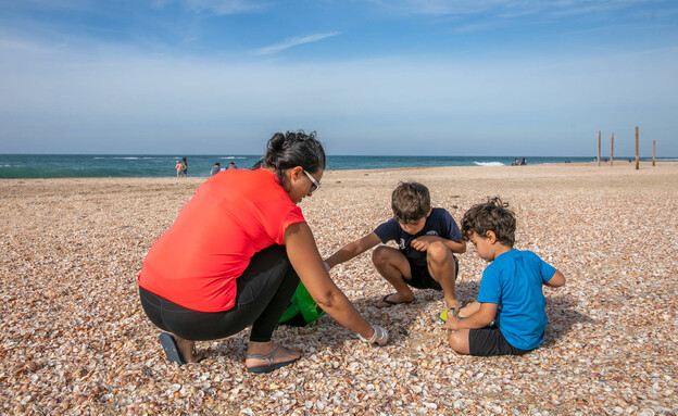 אם ושני ילדים אוספים זבל בחוף פלמחים (צילום: יוסי אלוני, פלאש 90)