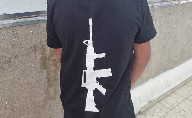 ילד הלובש חולצה עם הדפס של רובה אם-16