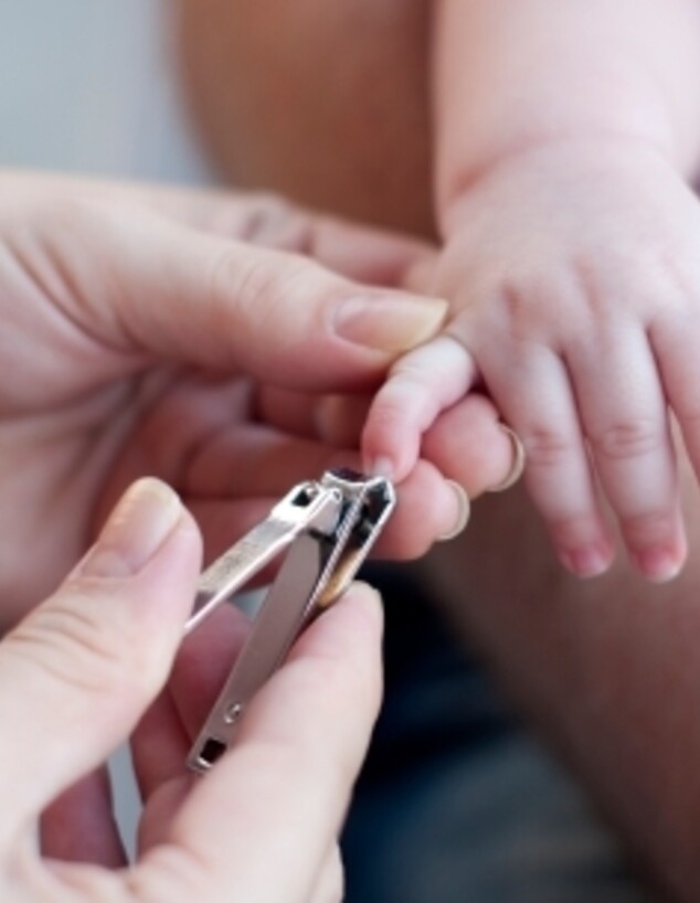 אמא גוזרת ציפורניים לתינוק