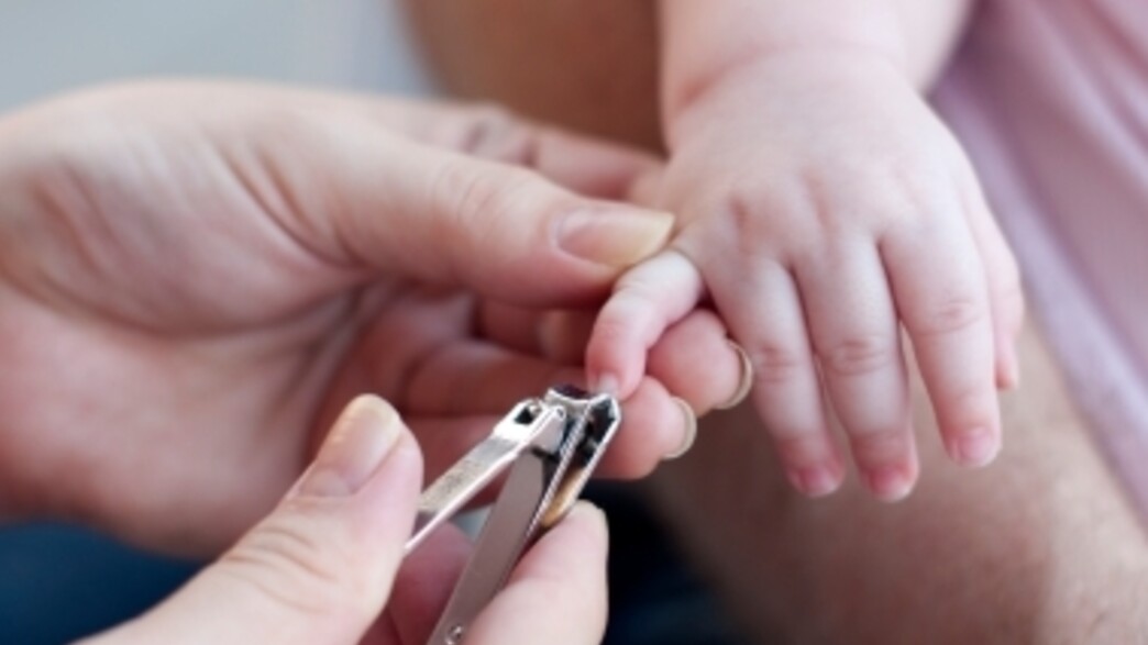 אמא גוזרת ציפורניים לתינוק