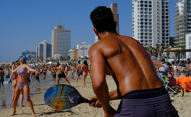 גבר משחק במטקות על החוף בתל אביב (צילום:  Alexi Rosenfeld/Getty Images)