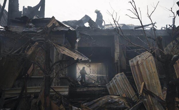 לוחם אש מכבה שריפה בבית הרוס, אוקראינה (צילום: AP)