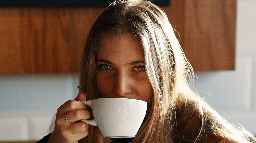 אישה צעירה שותה קפה (צילום:  Gian Cescon on Unsplash)