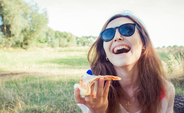 אישה אוכלת פיצה (צילום: tanja-vashchuk, Shutterstock)