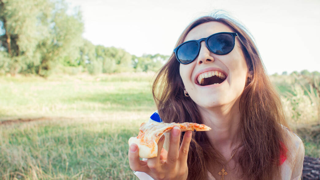 אישה אוכלת פיצה (צילום: tanja-vashchuk, Shutterstock)
