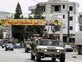 שיירת צבא ערבי על רקע דגלי חיזבאללה (צילום: Mahmoud ZAYYAT/AFP/GettyImages)