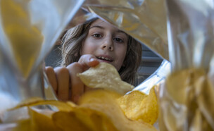 ילד אוכל חטיף צ'יפס מחבילה (אילוסטרציה: Getty Images)