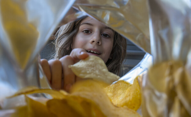 ילד אוכל חטיף צ'יפס מחבילה (אילוסטרציה: Getty Images)