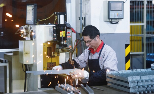 עובד סיני במפעל בהאנגז'ו (צילום: AFP, getty images)