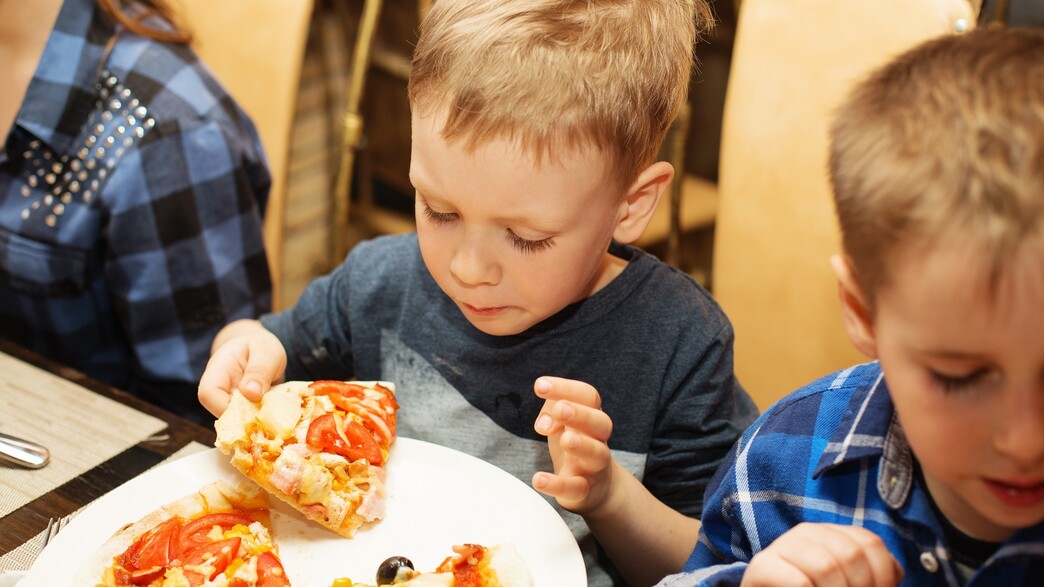 ילד אוכל פיצה (צילום: Nataliia Zhekova, shutterstock)