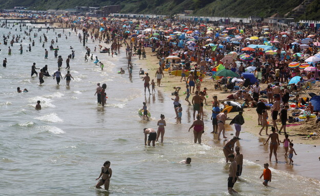 גל חום בבריטניה, רוחצים בחוף בורנמות' (צילום: Reuters)