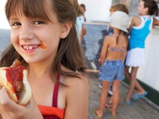 ילדה אוכלת נקניקייה עם קטשופ (צילום: אימג'בנק / Thinkstock)