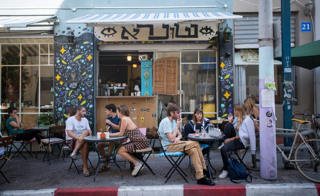 צעירים יושבים בבית קפה בכרם התימנים בתל אביב (צילום: מרים אלסטר, פלאש 90)
