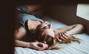 בחורה עם קעקועים במיטה חם (צילום: unsplash)