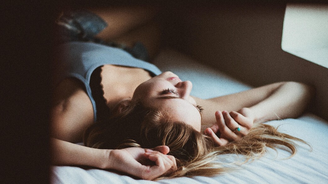 בחורה עם קעקועים במיטה חם (צילום: unsplash)