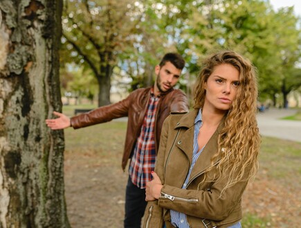 גבר ואישה לבושים במעילי עור עומדים ליד עץ (אילוסטרציה: Vera Arsic, pexels)